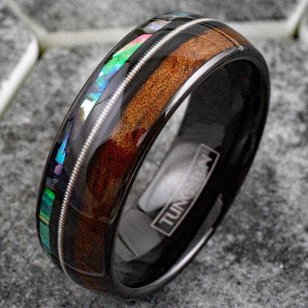 Cool Polished Black Tungsten Low Dome Ring with Silver Guitar String Between Iridescent Abalone And Whiskey Barrel Oak Wood Inlays.