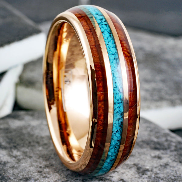 Gleaming Polished Rose Gold Low Dome Tungsten Ring with Crushed Blue Turquoise Inlay Between Koa Wood Inlays.