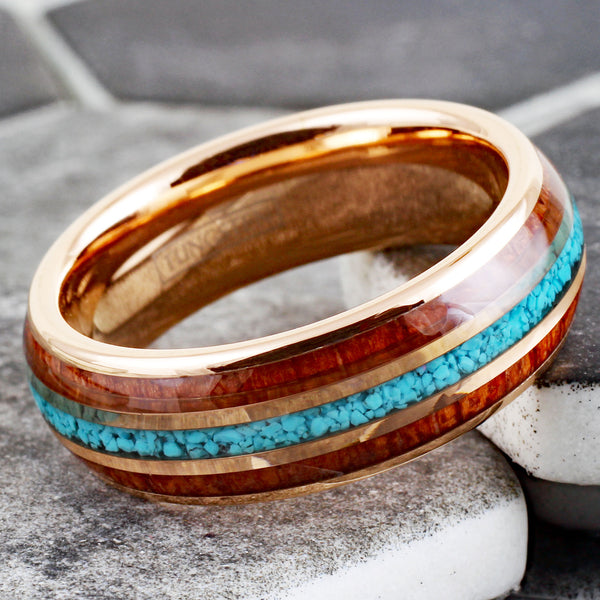 Gleaming Polished Rose Gold Low Dome Tungsten Ring with Crushed Blue Turquoise Inlay Between Koa Wood Inlays.