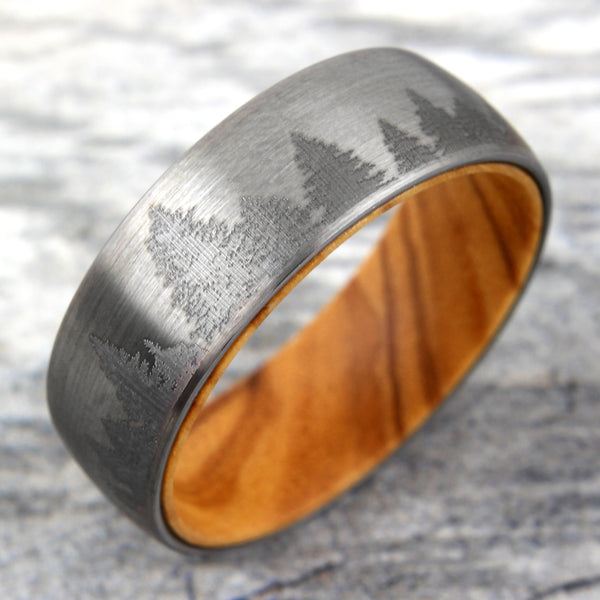 Brushed Finish tungsten carbide band ring w/ etched forest scene & olive wood inner band | Marble tilted photo